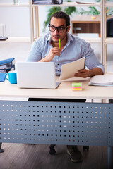 Fototapeta premium Young male employee working in the office