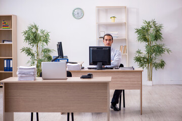Young male employee sitting in the office
