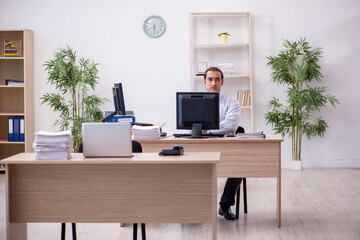 Fototapeta premium Young male employee sitting in the office