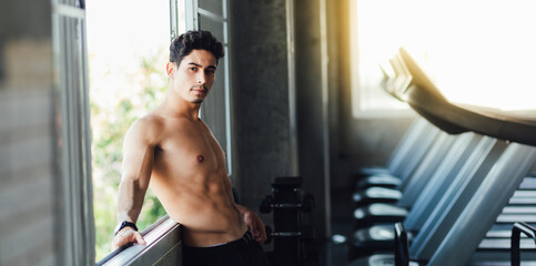 Portait Handsome young man while resting at gym. Man training in a gym Fitness.workout, exercises and healthy concept