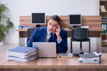 Young male employee unhappy with excessive work