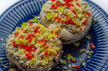 Mushrooms stuffed with onion, garlic, leek, paprika and sprinkled with cheese and breadcrumbs, snack prepared for baking