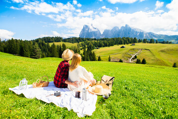 Romantic couple visiting Alpe di Siusi mountains, Italy. 
Boyfriend and girlfriend in love enjoying...
