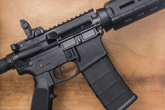 Loaded AR-15 semi-auto assault rifle gun on a wooden background with a 30 round magazine