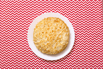 Pancakes on a plate, stand on a tablecloth top view. Russian traditional holiday Maslenitsa.