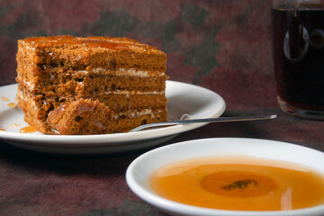 honey cake with honey drips lies on a white plate
