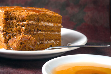honey cake with honey drips lies on a white plate