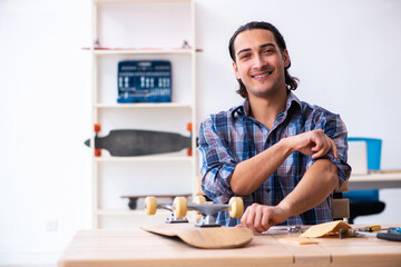 Young man repairing skateboard at workshop