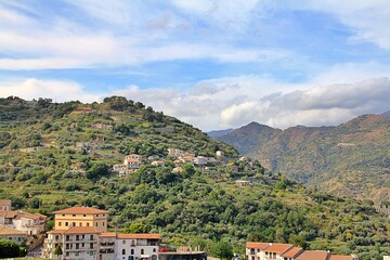 Fototapeta na wymiar mountains, valleys, hills with vegetation and houses built on the hills, the sky with clouds, Sicily, Italy
