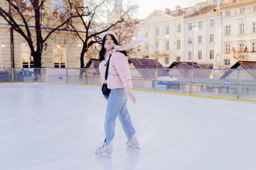Pretty young asian woman at ice-skating rink, outdoor.