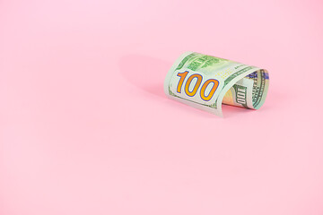 One hundred dallars on a pink background.