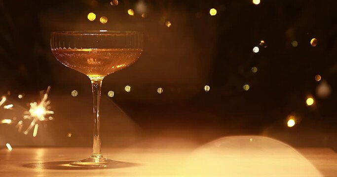 one Glass Of Champagne And Dark Background With Festive Gold Lights And New Year Sparkler.
