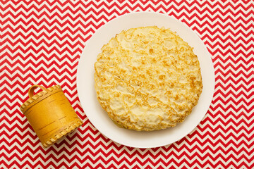 Pancakes on a plate, top view and a barrel of honey. Russian traditional holiday Maslenitsa.
