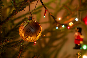 Christmas tree toy on the tree. Golden ball on the Christmas tree.