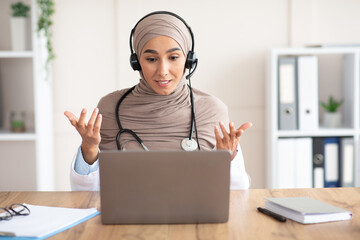 Muslim woman doctor working online from clinic