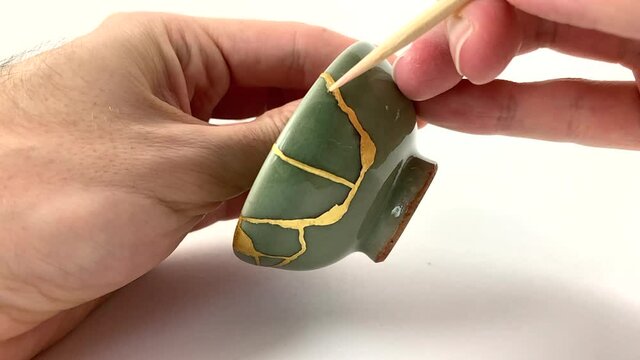 Artisan working on kintsugi process. Slow motion cinematic Kintsukuroi video. cleaning phase.