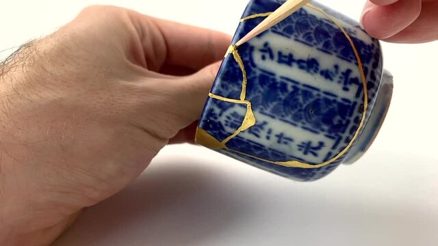 Artisan working on kintsugi process. Slow motion cinematic Kintsukuroi video. cleaning phase.