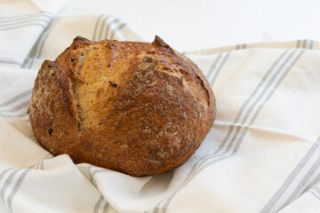Freshly baked homemade bread with linen cloth, front horizontal view.