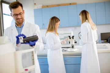 Obraz premium Researcher in protective workwear standing in the laboratory and analyzing liquid samples