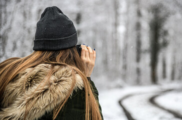 Frau geht in den verschneiten Wald