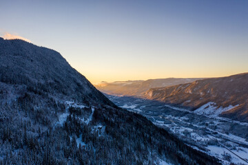 Drone photo from winter land Norway, Gol, Hallingdal. Shot in the cold in January in the blue hours early morning. Sun is rising and the frozen landscape is thawing. 