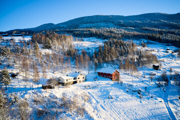 Drone photo from winter land Norway, Gol, Hallingdal. Shot in the cold in January in the blue hours early morning. Sun is rising and the frozen landscape is thawing.  © SteinOve