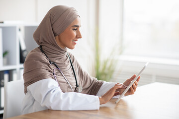 Female doctor muslim woman using digita tablet - obrazy, fototapety, plakaty