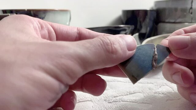 Artisan working on kintsugi process. Slow motion cinematic Kintsukuroi video. Rebuilding phase.
