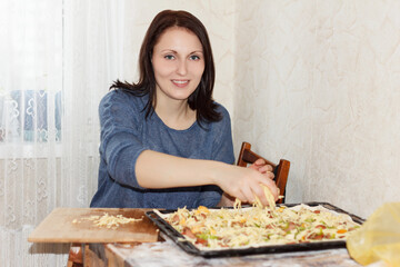 Brunette girl preparing a pizza for the family