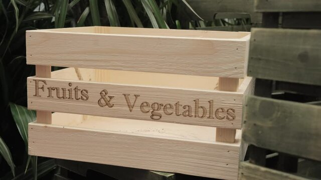 Women hands put wooden box with inscription fruits and vegetables. Then woman puts lime in box. Concept of healthy organic food, growing plant in city