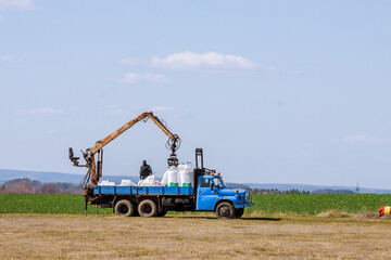 Fototapeta premium Tractor spreading fertilizer on grass field. Agricultural work.