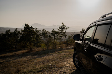 interesting travel adventure tourism in the mountains. Sunny sunset. the car stands and looks...