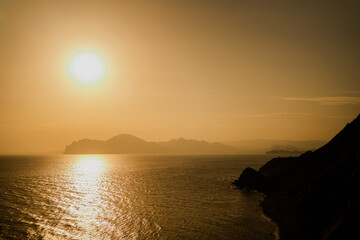 panoramic view of the sky. the sea washes the coast in straight lines. screen saver on the screen. high mountains sand-colored hills.