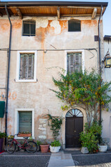 Fototapeta na wymiar Traditional ancient house on Garda Lake, Italy. A bicycle is near the house