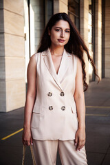 young pretty brunette woman in fashion suit at business building posing cheerful, lifestyle people concept