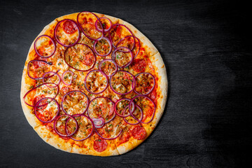  Italian pizza with sausage and onion rings on black background, top view