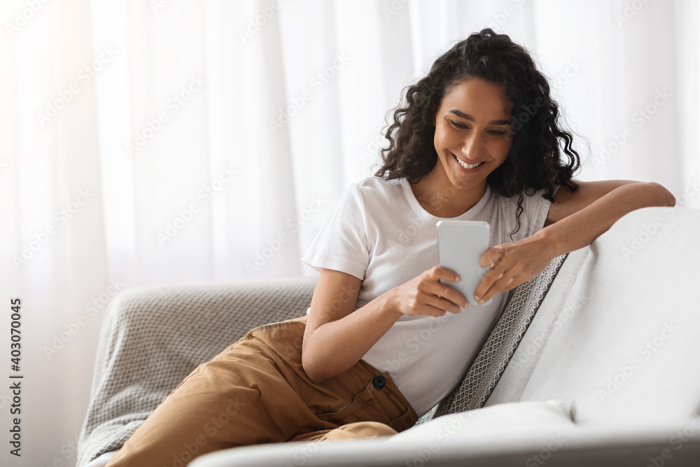 Wall mural happy woman using mobile phone at home