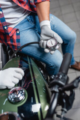 selective focus of manometer in hands of technician measuring air pressure in tire of motorcycle
