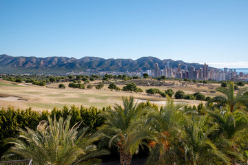 Fototapeta na wymiar Extensive panoramic view of Benidorm, Spain with the skyline and the sea in the background from the extraordinary golf courses that surround the city