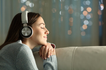 Profile of a woman listening to music in the night at home