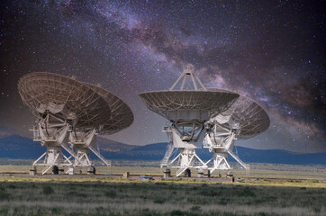Four antennas that are part of the Very Large Array system in New Mexico, with the Milky Way in the...
