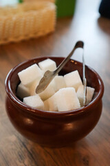 white sugar cubes in a bowl on a wooden table in cafe