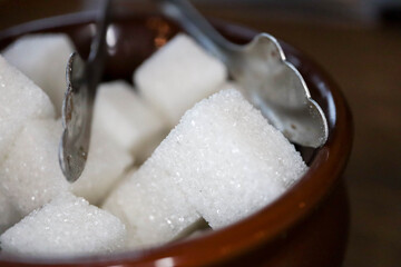 white sugar cubes in a bowl on a wooden table in cafe