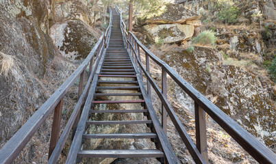 Long wooden staircase in the mountains at sunset