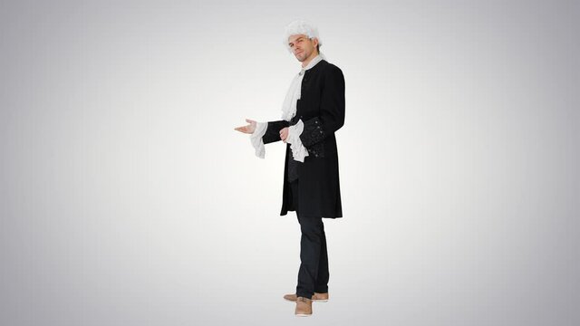 Man in 18th century camisole and wig doing welcoming gesture on gradient background.
