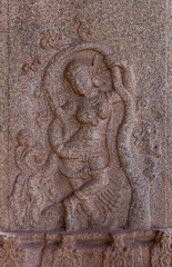 Hampi, Karnataka, India - November 4, 2013: Hazara Rama Temple. Closeup of brown stone pillar sculpture of dancing woman.