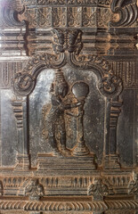 Hampi, Karnataka, India - November 4, 2013: Hazara Rama Temple. Closeup of black marble sculpture of king Rama and pillar with sun. 