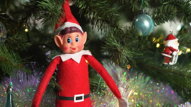 Christmas elf sitting on sparkling Christmas tree