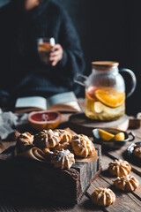Woman is reading and Hot tea with fresh grapefruit on wooden tablet. Healthy drink, Eco, vegan.