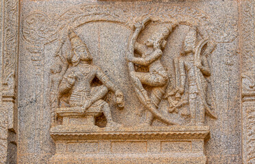 Hampi, Karnataka, India - November 4, 2013: Hazara Rama Temple. Closeup of beige stone damaged sculpture on wall featuring visitors with gifts to the king.